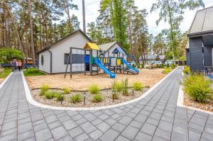 a playground with a slide and a play structure at Domki Bursztynowy Resort in Jarosławiec