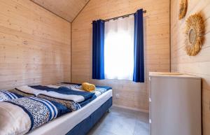 a bed in a wooden room with a window at Domki Bursztynowy Resort in Jarosławiec