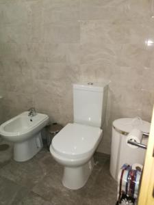 een badkamer met een wit toilet en een wastafel bij Casa Manuel in Manteigas