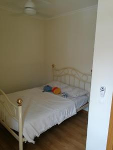 een slaapkamer met een wit bed met een knuffeldier erop bij Casa Manuel in Manteigas