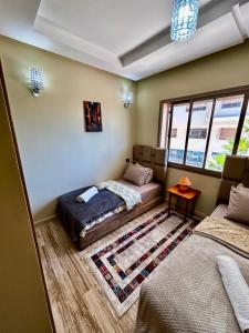 a bedroom with a bed and a couch and a window at Ocean side - Prestige & Douceur familliale in Casablanca +19 photos