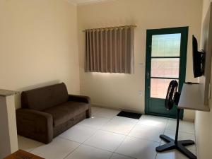 a living room with a couch and a window at Flat Thermas Olimpia - 300 metros do Thermas dos Laranjais in Olímpia