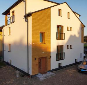 a house with a wooden facade and a garage at Niwy8Rooms in Oświęcim
