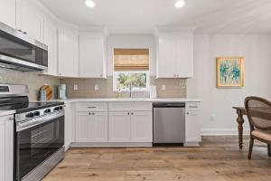 a white kitchen with white cabinets and a window at Home Run House - King Bed - Loft - Sports Complex in Youngsville