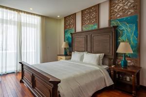 a bedroom with a large bed and two tables with lamps at Casa de LYN Nha Trang in Nha Trang +88 photos