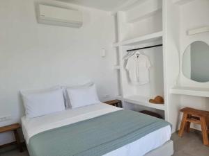 a white bedroom with a bed and a mirror at Anemone ΙΙ house w private pool 5 min from beach in Ios Chora