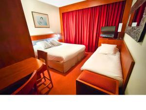 a hotel room with two beds and a desk at Hôtel & Résidence Octel in Portet-sur-Garonne +37 photos