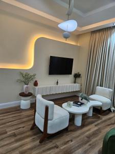 a living room with a couch and a tv at Eko Luxury Apartments in Ikeja