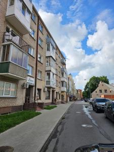 an empty street next to a building with parked cars at Klaipėda Old Town Stay in Klaipėda