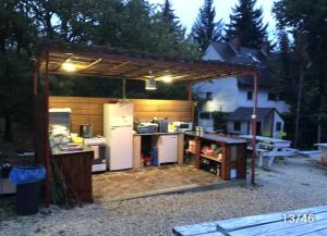 a backyard kitchen with a pavilion with a refrigerator at Pálköve Apartmanház in Kővágóörs
