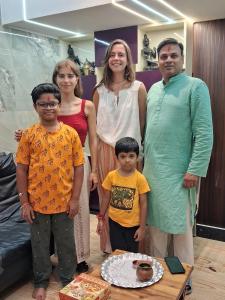 una famiglia che posa per una foto in un soggiorno di The Hideout Agra - Garden Homestay near Taj ad Agra