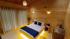 a bedroom with a bed in a wooden room at Wood Chalets Ella in Ella