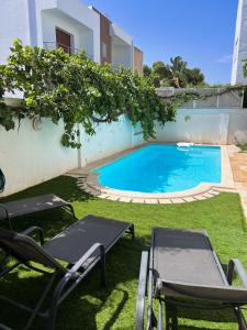 a swimming pool in a yard with lawn chairs at Sidi Bou Said-style villa with pool in Hammamet