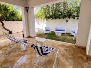 a group of chairs and tables in a courtyard at Sidi Bou Said-style villa with pool in Hammamet