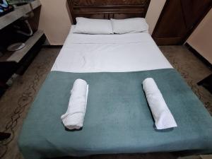 a bed with two white towels on top of it at Lindo flat Sabará Estilo Europa Vila Rica Pampulha in Venda Nova