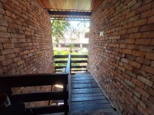 a brick wall with a bench in a hallway at Lindo flat Sabará Estilo Europa Vila Rica Pampulha in Venda Nova