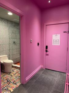 a bathroom with a pink door and a toilet at Hotel Hilo - Room 102 in Louisville +21 photos