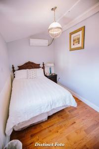 Un dormitorio con una cama blanca y suelo de madera. en Vacation House DC Free Parking, en Washington