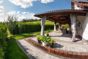 a pergola with potted plants on a patio at Dom w Chomranicach-domek grillowy in Chomranice