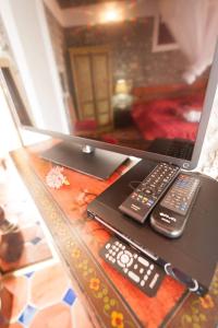 a laptop computer sitting on a table with two remote controls at Kristal Inn Cottage Caraïbes in Capesterre-de-Marie-Galante
