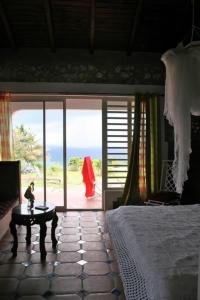 a bedroom with a bed and a view of the ocean at Kristal Inn Cottage Caraïbes in Capesterre-de-Marie-Galante