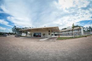 a building with a parking lot in front of it at Decio Hotel - Presidente Venceslau Antigo KHotel in Presidente Venceslau