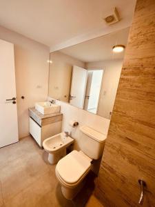 a bathroom with a toilet and a sink at Departamento de lujo con vista al mar in Monte Hermoso