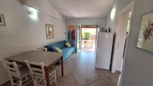 Una sala de estar con un sofá azul y una mesa. en Casa di Lu' - Bilocale con giardino - Porto Pollo, en Porto Pollo 18 fotos más