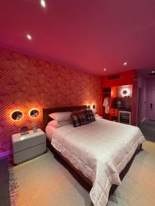 a bedroom with a large bed with red walls at Hotel Hilo - Room 202 in Louisville