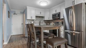 a kitchen with white cabinets and a stainless steel refrigerator at Plantation 4507 in Gulf Highlands +31 photos