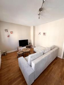 a living room with a couch and a flat screen tv at Le Pasteur - Cosy and Central in Roanne