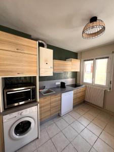 a kitchen with a washer and a washing machine at Le Pasteur - Cosy and Central in Roanne