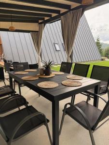 a black table and chairs in a patio at Monteluce Aframe in Mărişel