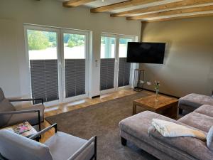 a living room with couches and a flat screen tv at Ferienwohnungen Harzblick in Bad Harzburg