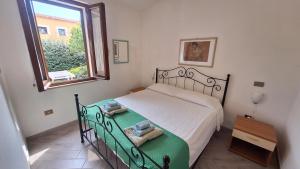 un dormitorio con una cama y una ventana en Casa di Lu' - Bilocale con giardino - Porto Pollo, en Porto Pollo