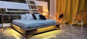 a bedroom with a bed and two chairs at WATO Villas in Bulindo