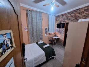 a bedroom with a bed and a table in a room at Lindo flat Serro Estilo Europeu Vila Rica Pampulha in Venda Nova