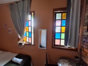 a room with a bed and a stained glass window at Lindo flat Serro Estilo Europeu Vila Rica Pampulha in Venda Nova