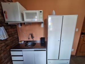 a kitchen with a white refrigerator and a microwave at Lindo flat Serro Estilo Europeu Vila Rica Pampulha in Venda Nova
