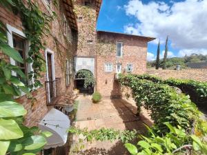 an external view of a brick building with ivy at Lindo flat Serro Estilo Europeu Vila Rica Pampulha in Venda Nova