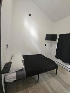 a bedroom with a bed with a black blanket and a lamp at Cabin Number 6 in Houston