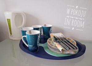 a tray with three coffee cups and plates on it at Satori in Władysławowo