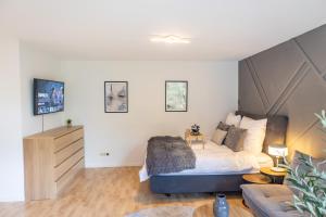 a bedroom with a large bed and a couch at Stilvolles Apartment in Siegen in Siegen