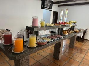 a table with a bunch of breakfast foods and drinks at Pousada Corais in Ubatuba