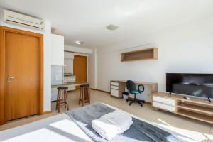 a bedroom with a bed and a television and a desk at Studio em cond. c/ Academia, Asa Norte SMZ407 in Brasilia