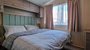 a bedroom with a bed and a window at Megerlilly Family Hideaway, Church Farm in Pagham