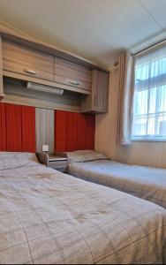 a room with two beds and a window at Megerlilly Family Hideaway, Church Farm in Pagham