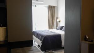 a bedroom with a bed in front of a window at Republica Suites - Departamento Nivel Ejecutivo2 in San Fernando del Valle de Catamarca