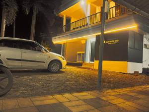 a white van parked in front of a building at Clap House Home in Guruvāyūr