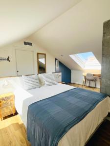 a bedroom with a large white bed with a skylight at Lembranza Guest House in Ponte Do Porto +53 photos